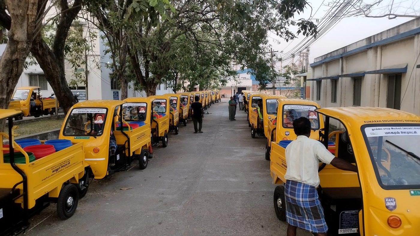 A long row of KAFE 300+ vehicles in panchayat livery, loaded with segregation bins, ready for handover